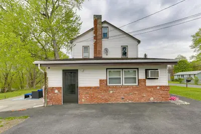 a white house with a brick at Waterfront Wallkill Duplex Home with Fire Pits! in Wallkill