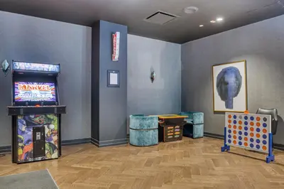 a room with a video game and a pinball machine at FiDi Studio w Residents Bar Golf Simulator Gym NYC-271 in New York