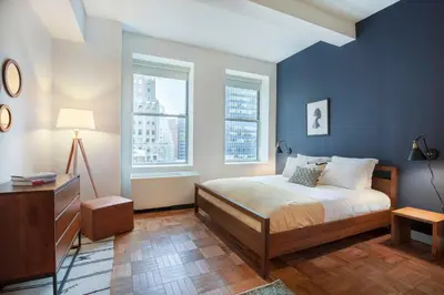 a bedroom with a bed and two windows at FiDi Studio w Residents Bar Golf Simulator Gym NYC-271 in New York