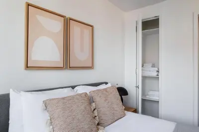 a bed with two pillows and two pictures on the wall at Tribeca Studio w Tons of light Gym Pool NYC-118 in New York