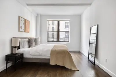 a white bedroom with a large bed and a window at UWS 1br w gym doorman nr Central Park NYC-1100 in New York