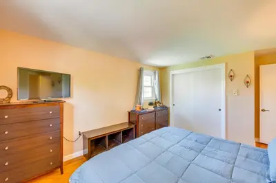 a bedroom with a bed and a dresser and a television at 10 Mi to Dtwn Lancaster Charming Home with Yard! in Leola