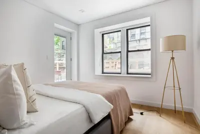 a white bedroom with a bed and a window at SoHo 1br w outdoor space in-unit wd NYC-1143 in New York