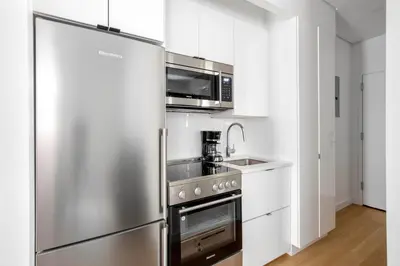 a kitchen with a stainless steel refrigerator and a sink at SoHo 1br w outdoor space in-unit wd NYC-1143 in New York