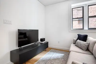a living room with a couch and a flat screen tv at SoHo 1br w outdoor space in-unit wd NYC-1143 in New York