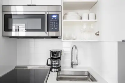 a kitchen with a sink and a microwave at SoHo 1br w outdoor space in-unit wd NYC-1143 in New York