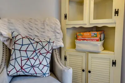 a room with a chair with a pillow and a cabinet at Fire Pit and Deck Inviting Pocono Lake Home in Pocono Lake