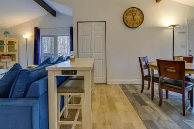 a living room with a blue couch and a table at Fire Pit and Deck Inviting Pocono Lake Home in Pocono Lake