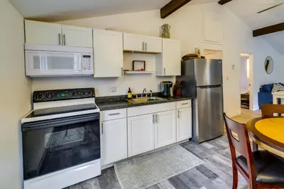 a kitchen with white cabinets and a stainless steel refrigerator at Fire Pit and Deck Inviting Pocono Lake Home in Pocono Lake
