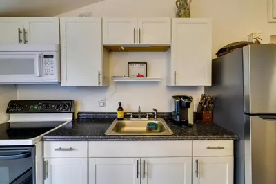 a kitchen with white cabinets and a sink at Fire Pit and Deck Inviting Pocono Lake Home in Pocono Lake