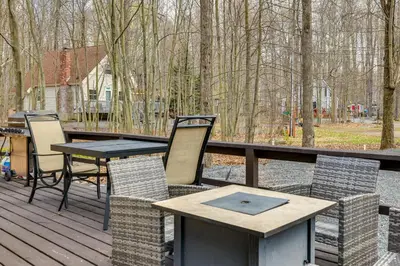 a deck with chairs and a table and a table and chairs at Fire Pit and Deck Inviting Pocono Lake Home in Pocono Lake