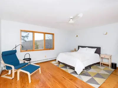 a bedroom with a bed and a blue chair at Catskills Escape - Serenity on 105 Acres, 2 hours from NYC in Ellenville