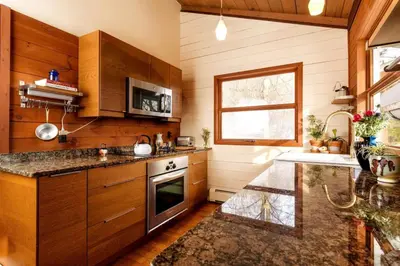 a kitchen with wooden cabinets and a sink and a stove at Catskills Escape - Serenity on 105 Acres, 2 hours from NYC in Ellenville