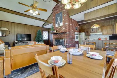 a dining room and living room with a table and chairs at Cozy Pocono Lake Cottage with Fire Pit and Ping Pong! in Pocono Lake