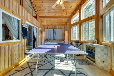 a ping pong table in a room with windows at Cozy Pocono Lake Cottage with Fire Pit and Ping Pong! in Pocono Lake
