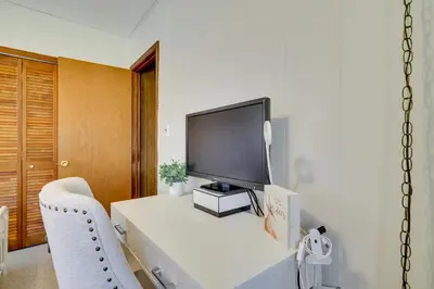 a living room with a television on a white table at Cozy Pocono Lake Cottage with Fire Pit and Ping Pong! in Pocono Lake