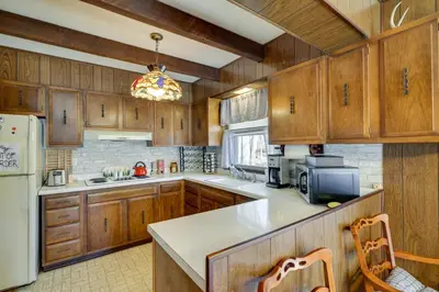 a kitchen with wooden cabinets and a white refrigerator at Cozy Pocono Lake Cottage with Fire Pit and Ping Pong! in Pocono Lake