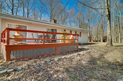 a house with a large deck in front of it at Cozy Pocono Lake Cottage with Fire Pit and Ping Pong! in Pocono Lake