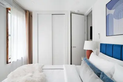 a bedroom with a white bed with a blue headboard at 48-3RW Brand New 1BR Prime Hells Kitchen - W D in New York