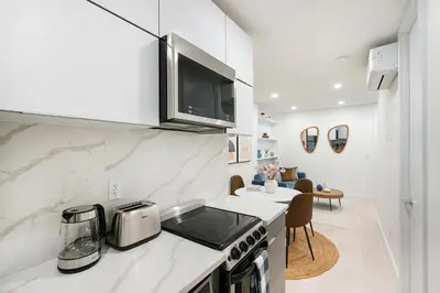 a kitchen with a microwave and a stove top oven at 48-3RW Brand New 1BR Prime Hells Kitchen - W D in New York