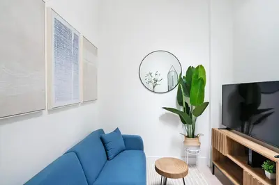 a living room with a blue couch and a tv at 48-5FE Brand New 2BR in prime Midtown in New York