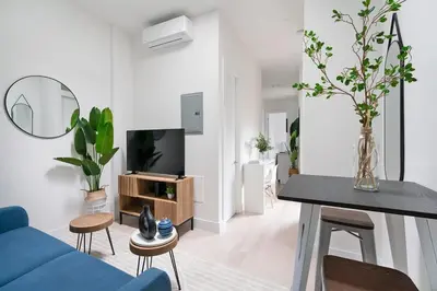 a living room with a blue couch and a tv at 48-5FE Brand New 2BR in prime Midtown in New York