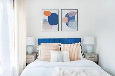 a bedroom with a bed with three pictures on the wall at 48-5FE Brand New 2BR in prime Midtown in New York