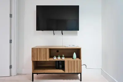 a flat screen tv on top of a wooden entertainment center at 48-5RW 1BR Apartment in Midtown West W D in New York