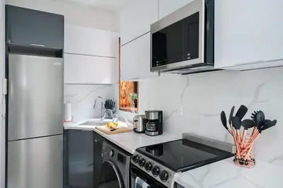 a white kitchen with a stove and a refrigerator at 48-5RW 1BR Apartment in Midtown West W D in New York