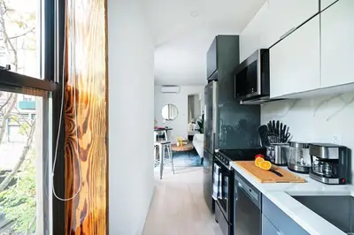 a kitchen with black and white appliances and a table at 48-1FE Brand New 1BR Prime hell's kitchen WD in unit in New York