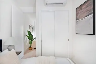 a white bedroom with a bed and a sliding door at 48-1FE Brand New 1BR Prime hell's kitchen WD in unit in New York