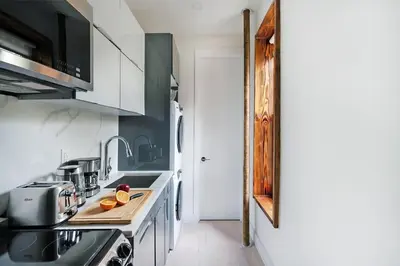 a kitchen with white cabinets and a counter top at 48-1FE Brand New 1BR Prime hell's kitchen WD in unit in New York