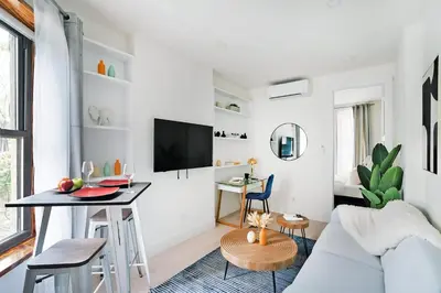 a white living room with a table and a couch at 48-1FE Brand New 1BR Prime hell's kitchen WD in unit in New York