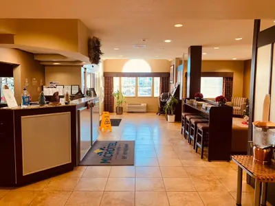 a restaurant with a kitchen with a counter and chairs at Microtel Inn & Suites-Sayre, PA in Sayre