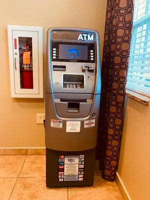 an atm machine sitting in a room next to a wall at Microtel Inn & Suites-Sayre, PA in Sayre