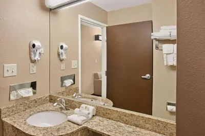 a bathroom with a sink and a mirror at Microtel Inn & Suites-Sayre, PA in Sayre