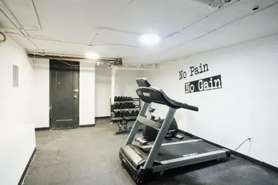 a gym with a treadmill and a sign on the wall at 74-1A New Studio in Prime UWS - GYM In Building in New York