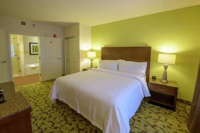 a hotel room with a large bed and a bathroom at Hilton Garden Inn Exton-West Chester in Exton