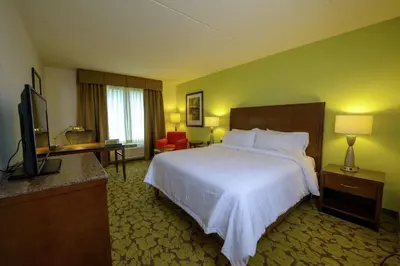 a hotel room with a bed and a flat screen tv at Hilton Garden Inn Exton-West Chester in Exton