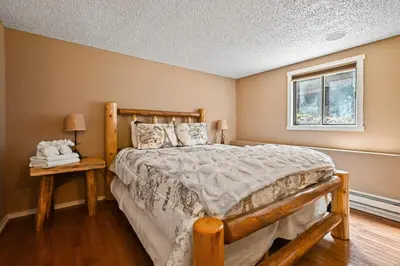 a bedroom with a wooden bed and a window at Tannersville Tranquility in Tannersville