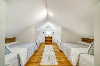 two beds in a room with white walls and wooden floors at Hot Tub and Lake Access at Poconos Getaway! in Lake Ariel
