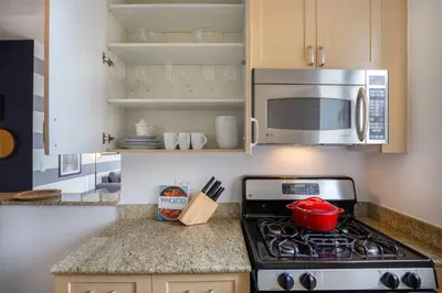 a kitchen with a stove and a microwave at Modern Bright Times Sq 1BR w Indoor pool NYC-8 in New York