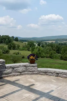 a vase of flowers sitting on a stone wall at Valley View Cabin in Morris