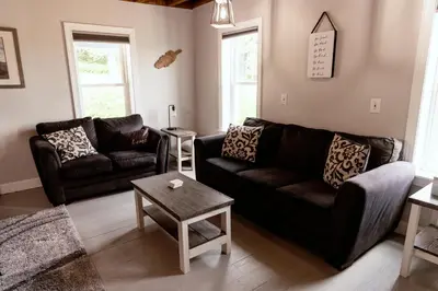 a living room with two couches and a table at Valley View Cabin in Morris