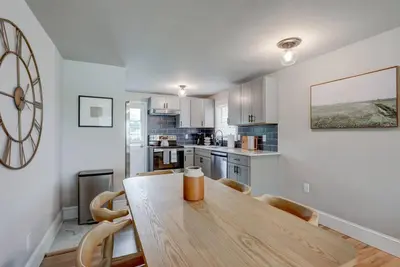 a kitchen with a wooden table and a large clock on the wall at Renovated 2 BR home close to Lancaster attractions in Lancaster