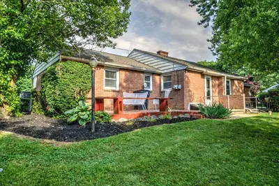 a brick house with a porch and a lawn at Renovated 2 BR home close to Lancaster attractions in Lancaster