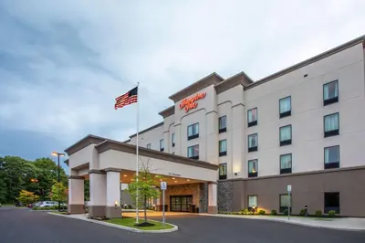 a hotel with an american flag on top of it at Hampton Inn Philadelphia/Voorhees in Voorhees