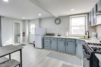 a kitchen with blue cabinets and a white refrigerator at Jersey City Vacation Rental about 8 Mi to NYC! in Jersey City