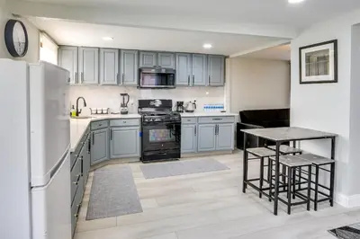 a kitchen with blue cabinets and a table and a stove at Jersey City Vacation Rental about 8 Mi to NYC! in Jersey City