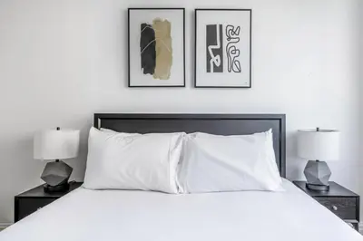 a bedroom with a white bed with two lamps at Sq 1BR w Great views Indoor pool NYC-29 in New York